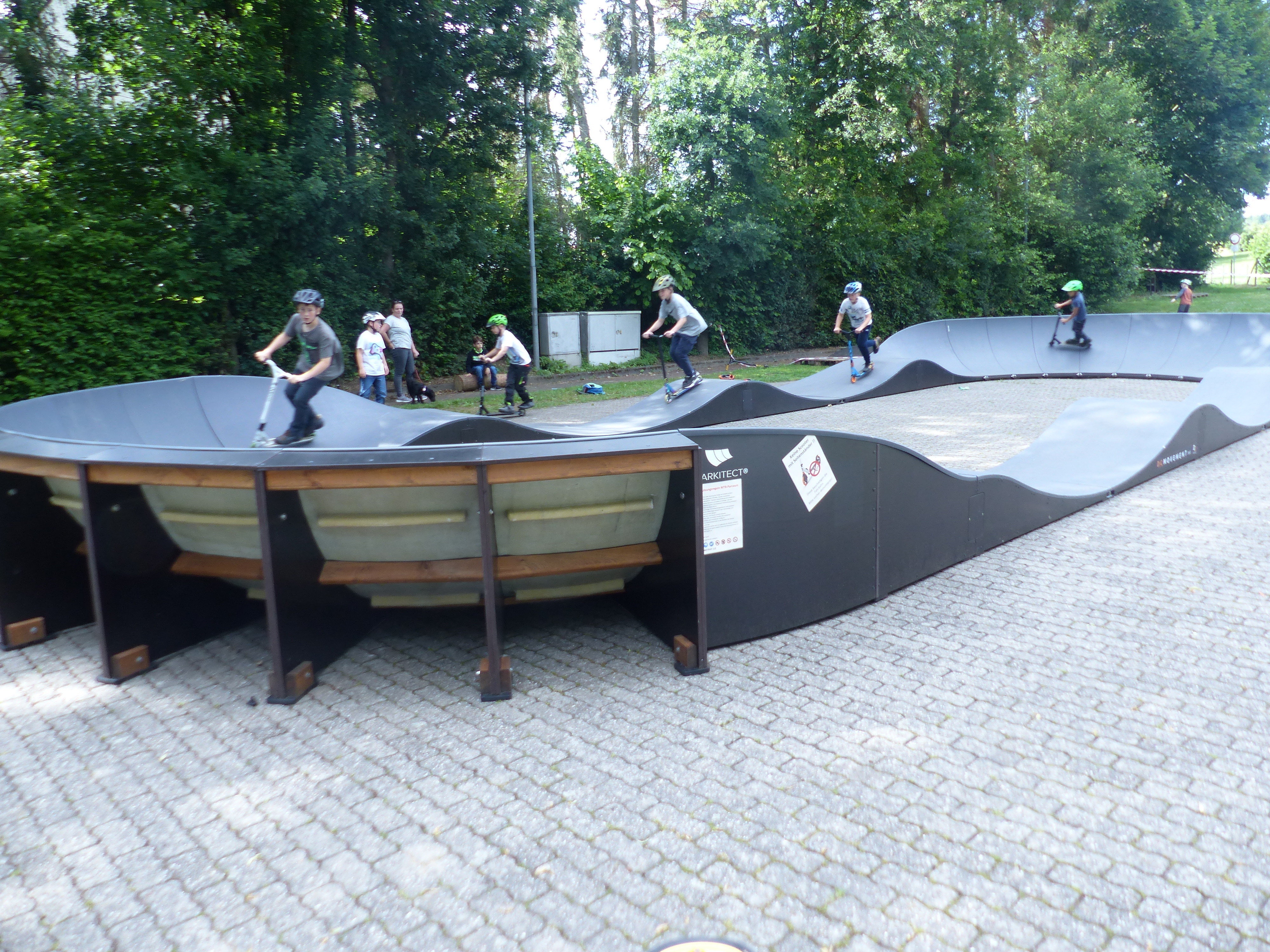 Kinder, die auf einer Pumptrack-Anlage fahren